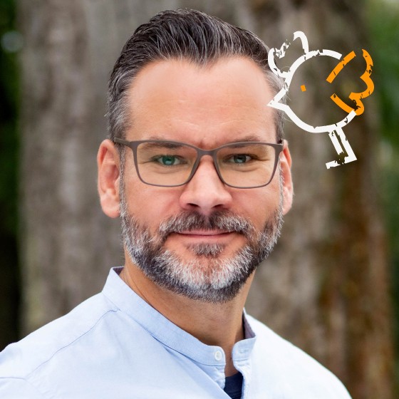 Ein kleiner illustrierter Vogel ist rechts neben Thomas' Kopf zu sehen.