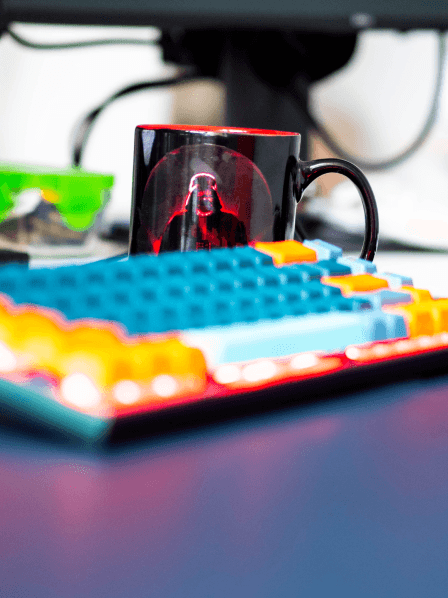 Eine bunte Tastatur und Star Wars Tasse.