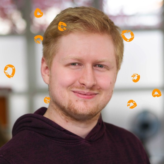 Dominiques Kopf ist umgeben von orangen kleinen Kreisen.