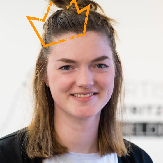 Eine orange Krone leuchtet auf Melinas Kopf.
