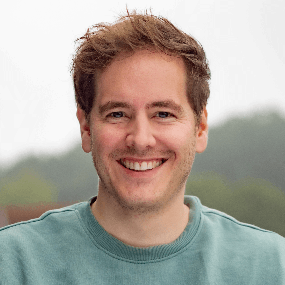 Julian hat braunes Haar und ein breites Lächeln.