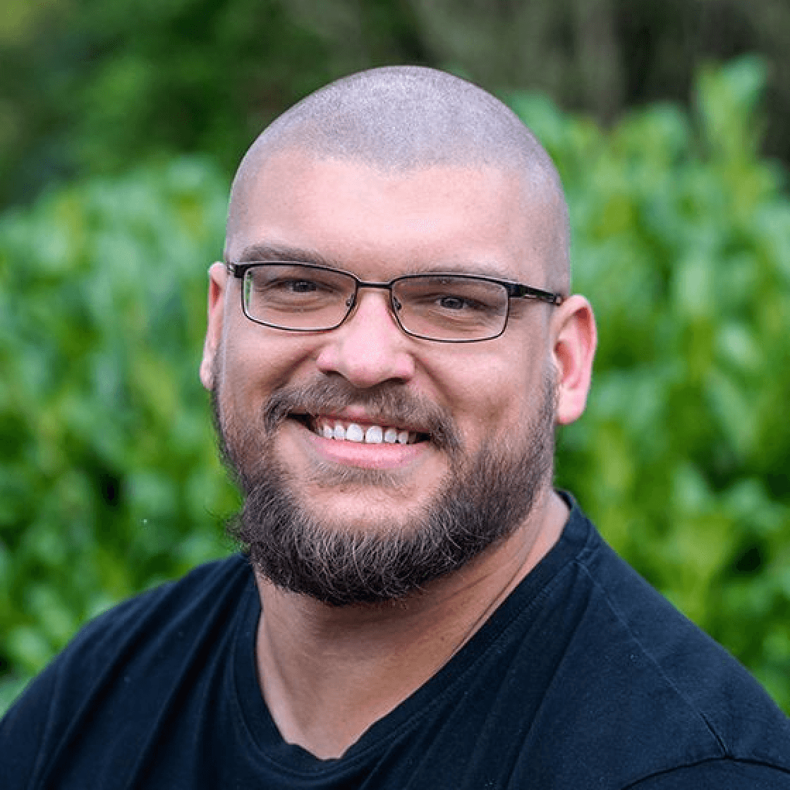 Kevin B. hat einen Vollbart und eine Brille mit schwarzem Gestell.