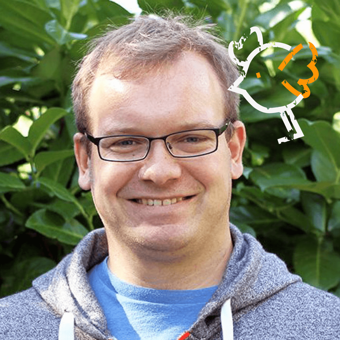 Dieses Porträt zeigt Christoph, einen Mann mit kurzem, hellbraunem Haar, Brille und einem freundlichen Lächeln. Er trägt ein blaues T-Shirt unter einer grauen Kapuzenjacke, was einen entspannten und authentischen Look vermittelt. Der grüne Hintergrund mit Blättern sorgt für eine natürliche, frische Atmosphäre. Ein besonderes Highlight: Die gezeichnete Vogel-Illustration in der oberen rechten Ecke verleiht dem Bild eine kreative und verspielte Note. 