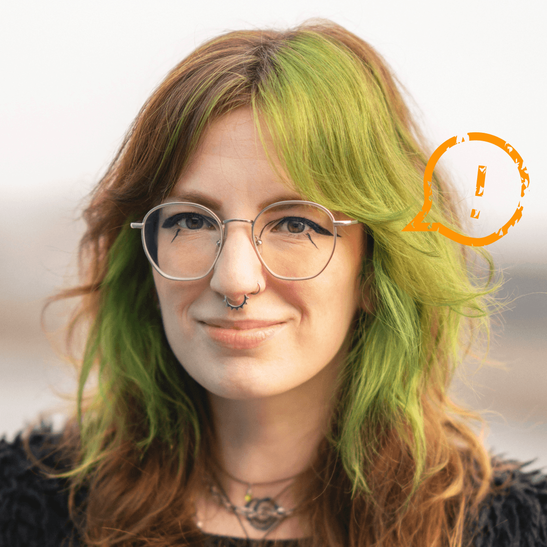 Porträt von Valeria mit grün-braunem Haar, Brille und Piercing. Im Vordergrund trägt sie ein dezentes Lächeln, im Hintergrund erscheint ein stilisiertes, orangefarbenes Ausrufezeichen in einer Sprechblase – Symbol für Aufmerksamkeit oder Hinweis.