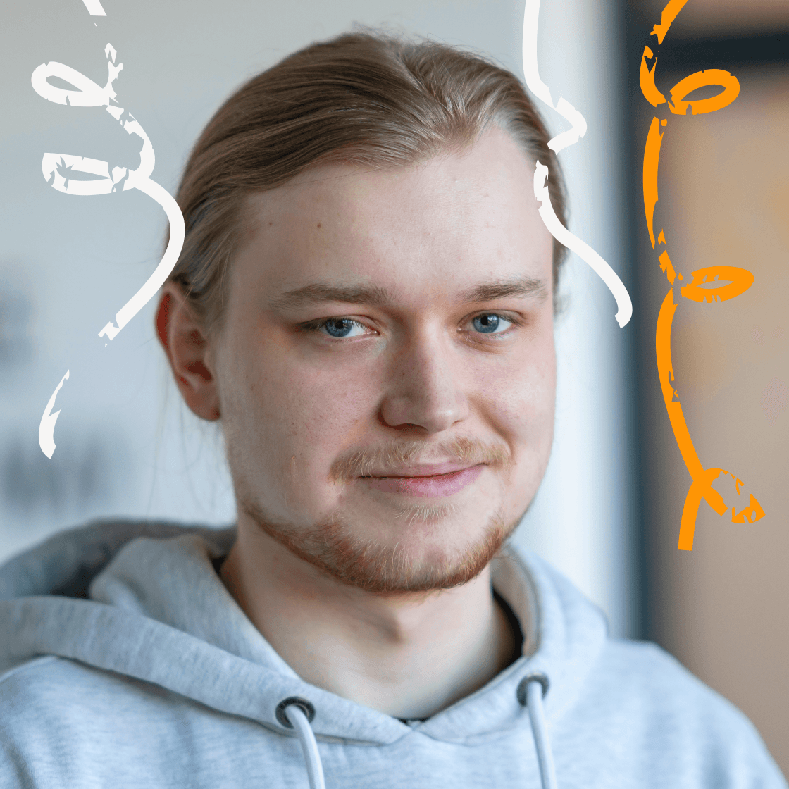 „Porträt von Alexander mit langen, hellblonden Haaren im Zopf und hellgrauem Hoodie. Er lächelt ruhig in die Kamera. Links und rechts umrahmen dynamische, weiße und orangefarbene grafische Linien das Bild – ein Symbol für Energie, Kreativität oder Aufbruch. Der Hintergrund zeigt eine moderne Indoor-Umgebung in hellen Farben.