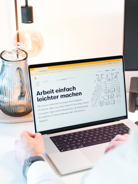 MacBook zeigt Unternehmenswebsite mit IT-Lösungen für moderne Arbeitswelten.