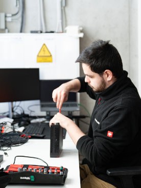 Dennis schraubt Hardware mit Werkzeug auf für professionelle Wartung.