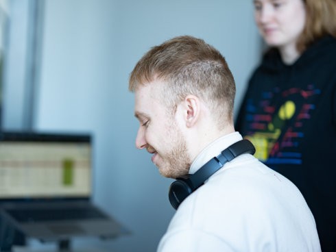 Zwei IT-Kollegen besprechen Daten am Laptop und arbeiten gemeinsam im Büro.