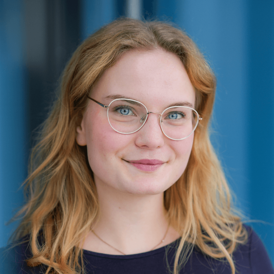 Portrait von Hannah, duale Studentin bei MANDARIN, lächelnd vor hellem Hintergrund