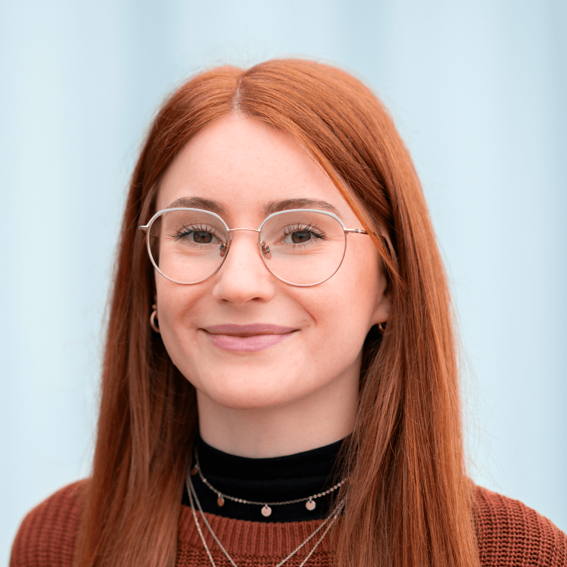 Portrait von Luisa, Trainee im Online Marketing bei MANDARIN, lächelnd vor hellem Hintergrund