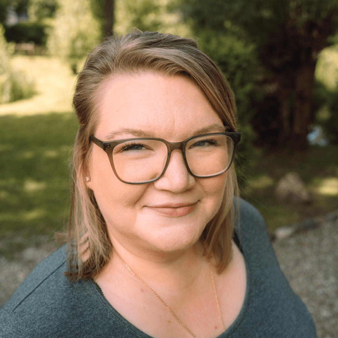 Portrait der Projektmanagerin Annika, mit Brille und dezentem Lächeln, professionell und freundlich wirkend.