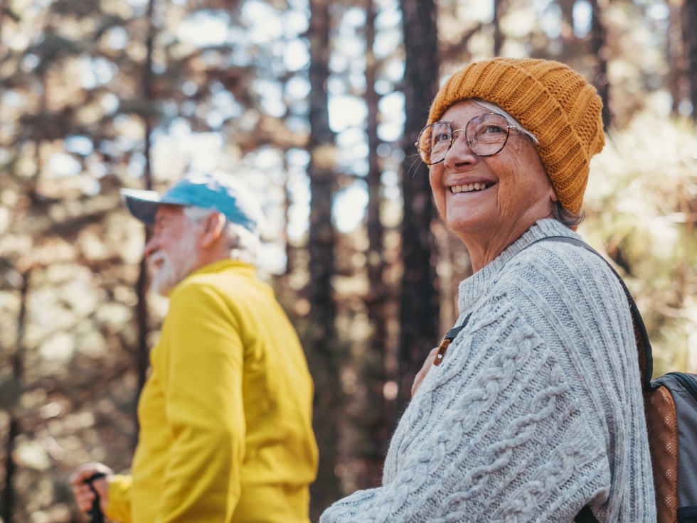 Zwei Menschen im herbstlichen Wald, tragen Outdoor-Kleidung und Strichwaren