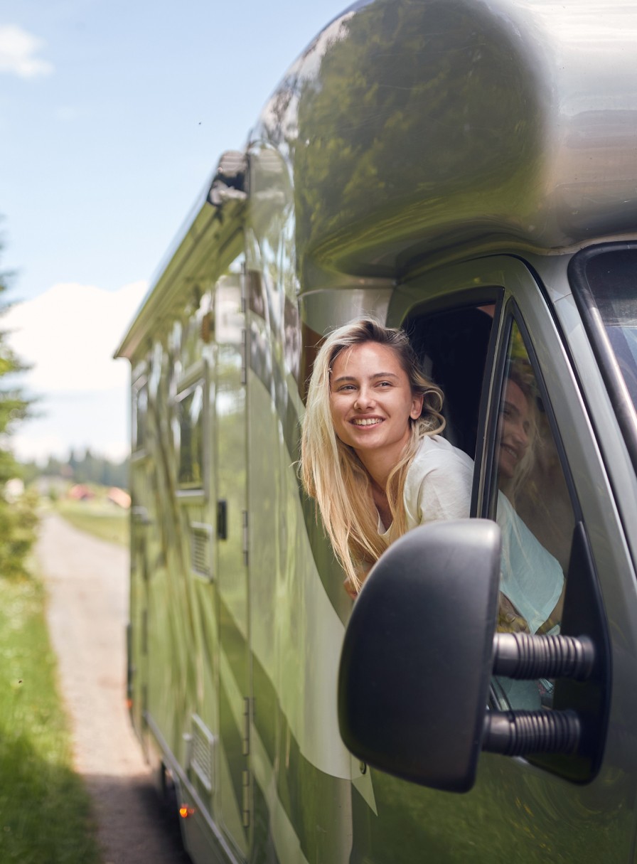 Frau schaut aus dem Beifahrerfenster eines Wohnmobils heraus