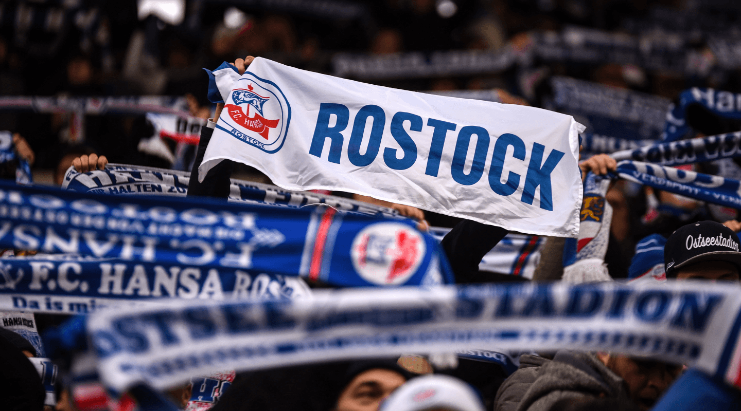 Blick auf eine Fankurve mit Hansa Schals und Fahnen