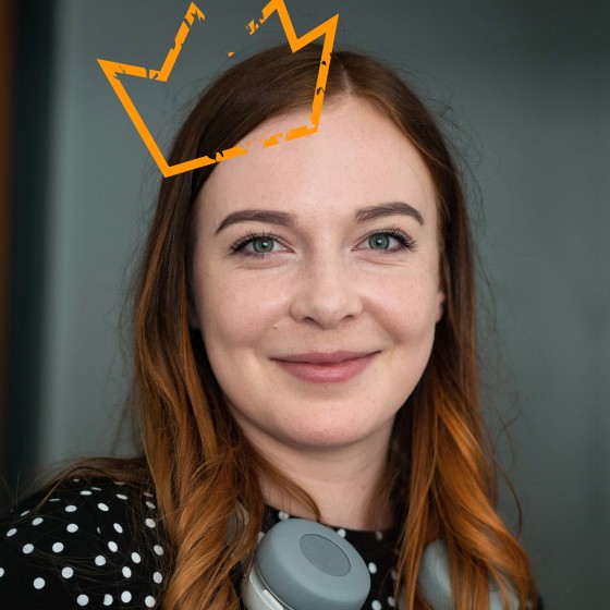 Auf Anjas Kopf sitzt eine orange Krone.