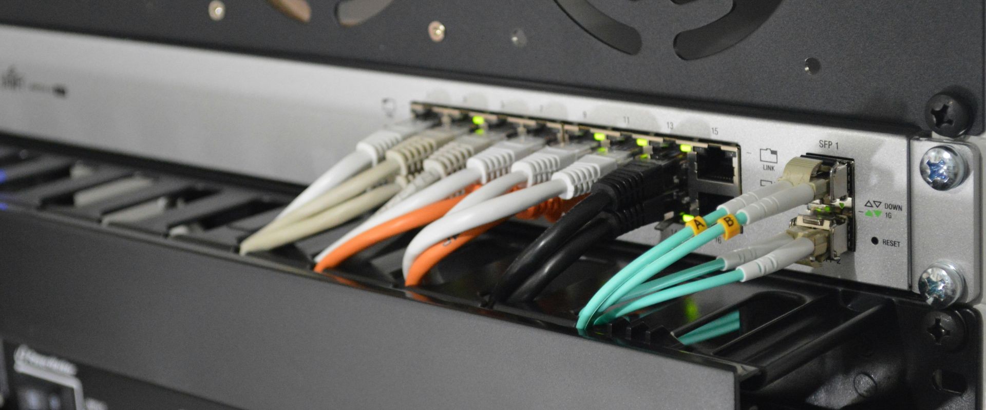 Netzwerk-Router mit verschiedenen Ethernet- und Glasfaserkabeln, die an die Ports angeschlossen sind.