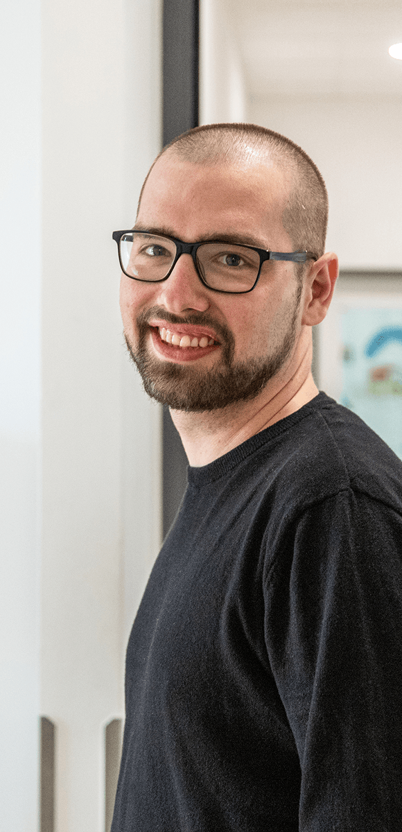 Mitarbeiter des Internationalen Bundes lächelt in die Kamera – authentische Einblicke in soziale Berufe mit Sinn und Entwicklungsperspektive.