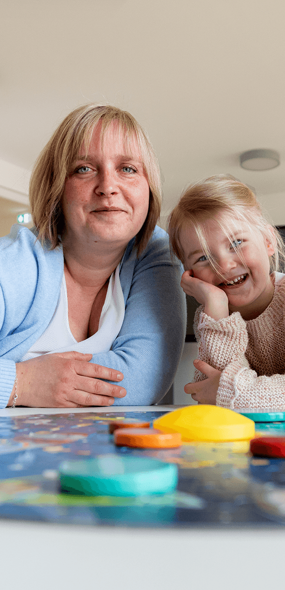 Pädagogische Fachkraft des Internationalen Bundes mit fröhlichem Kind beim gemeinsamen Spiel – liebevolle Betreuung in der Kita oder sozialen Einrichtung.