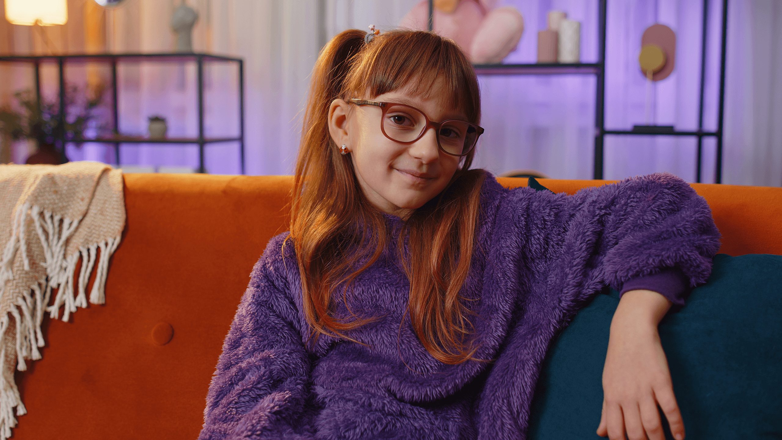 Mädchen mit Mutismus sitzt entspannt auf dem Sofa – Mutismus e.V. unterstützt Kinder mit selektivem Mutismus und bietet Informationen sowie Hilfe für Familien.