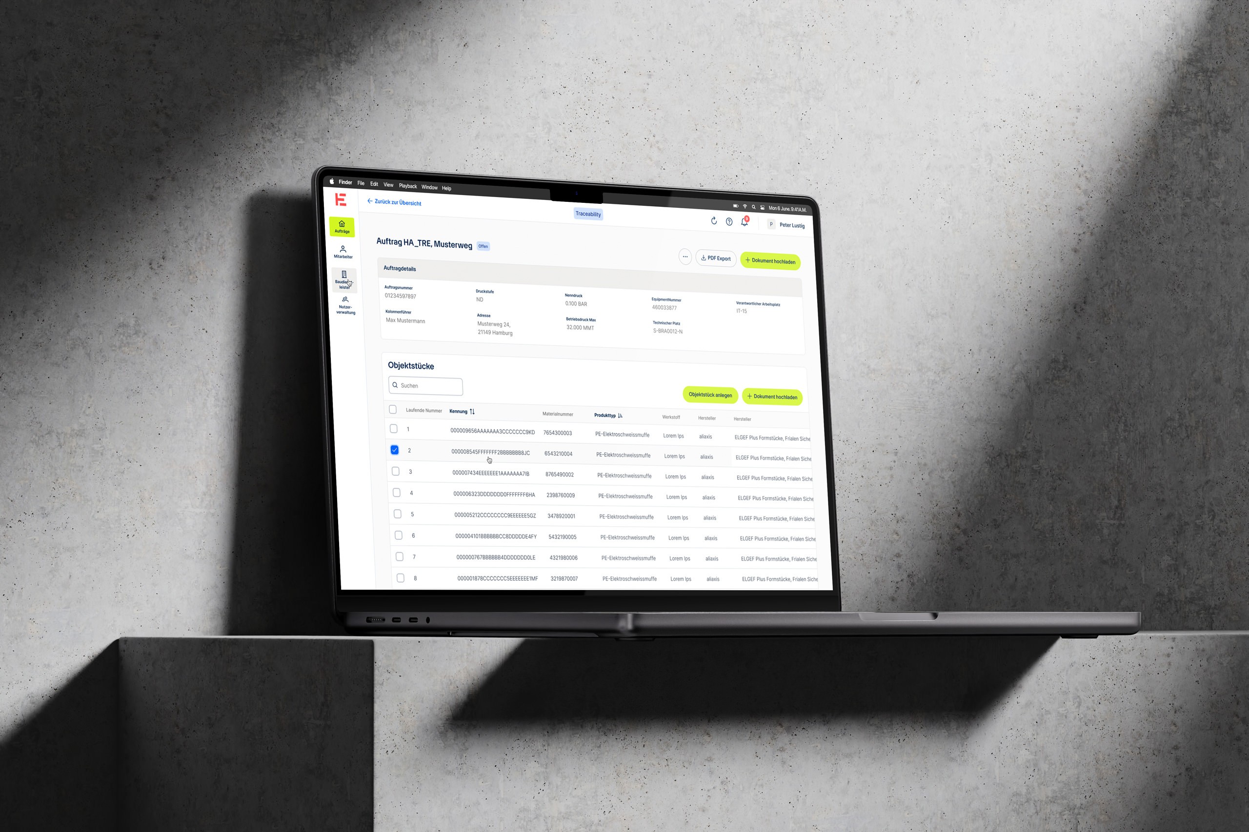 Ein MacBook auf einer grauen Betonoberfläche zeigt die Benutzeroberfläche einer Software zur Verwaltung von Hamburger Energienetze.