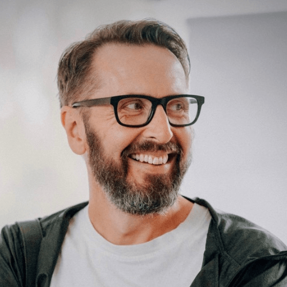Portrait Mann mit Brille lächelt zur Seite