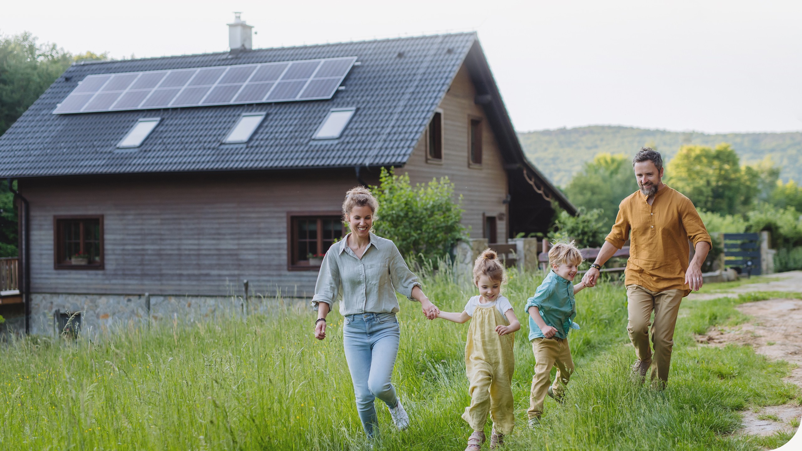 Eine Familie ist zusammen im Garten vor ihrem Wohnhaus.